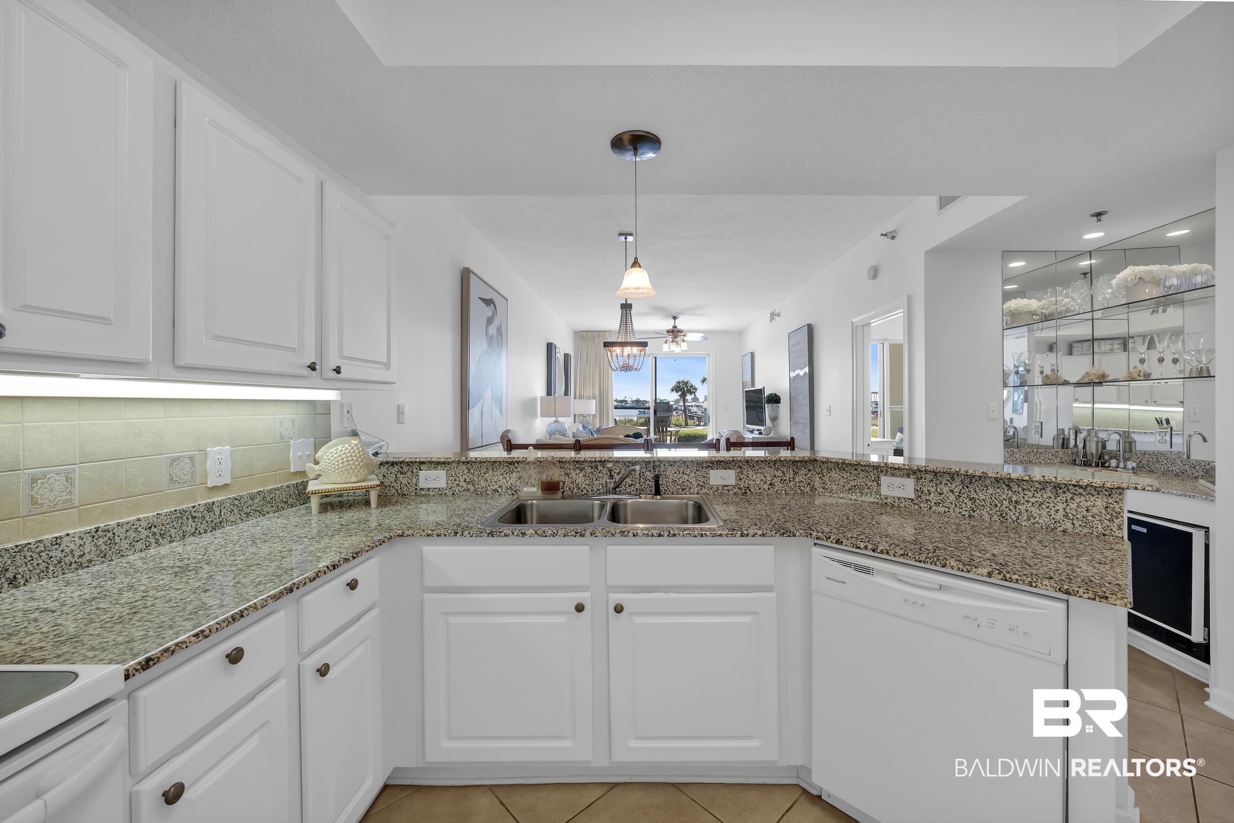27282 Canal Road, Unit 104 Orange Beach, AL 36561 - Photo 15 of 79 Kitchen with white cabinetry, white appliances, light tile patterned floors, a peninsula, and decorative light fixtures