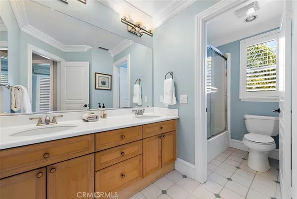 a bathroom with a double vanity sink toilet and a mirror