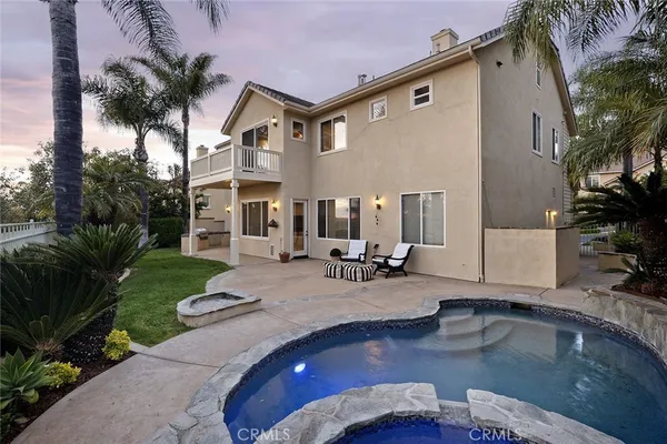 a view of a house with backyard swimming pool and sitting area