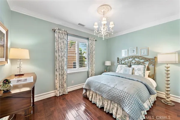 a bedroom with a bed wooden floor and a window