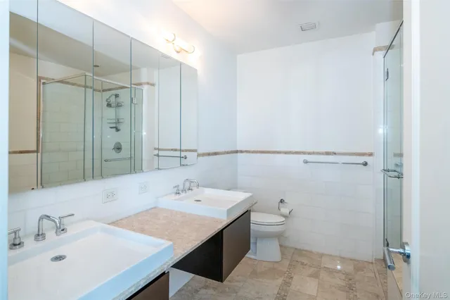 a bathroom with a sink a toilet and shower