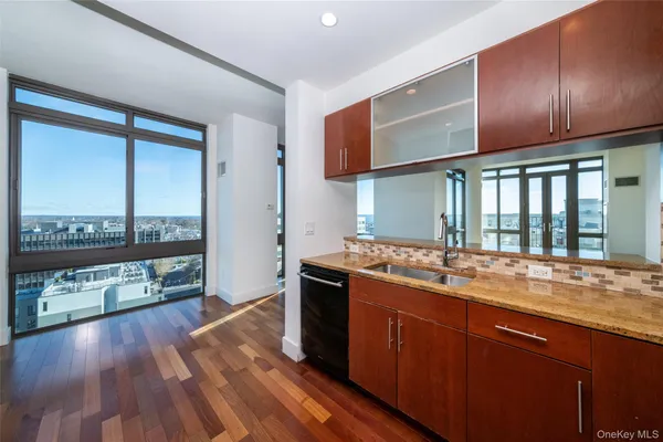 a kitchen with stainless steel appliances granite countertop a stove and a wooden floors