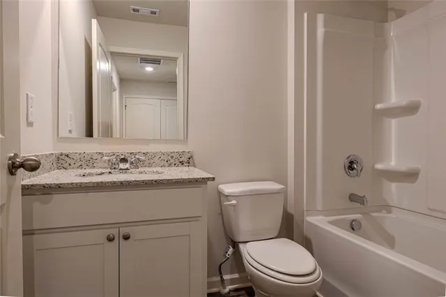 a bathroom with a sink toilet vanity and shower
