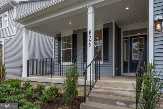 a view of an empty room with wooden floor fireplace and a window