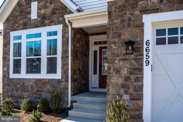 a large white kitchen with wooden floors and stainless steel appliances
