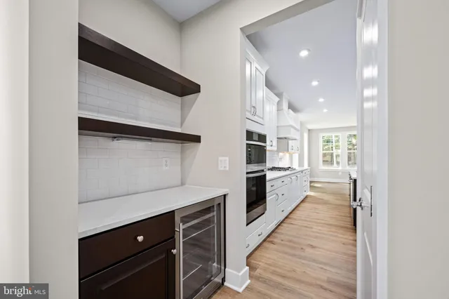 a view of an empty room with wooden floor and closet