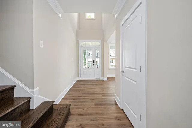 a view of a hallway with wooden floor and staircase