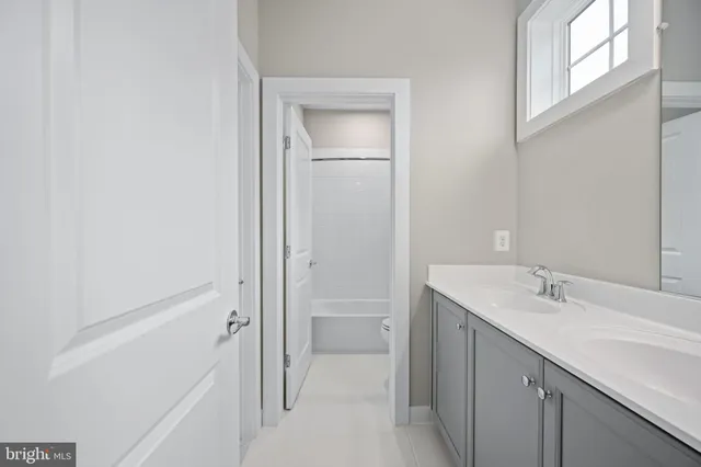 an empty room with wooden floor chandelier and windows