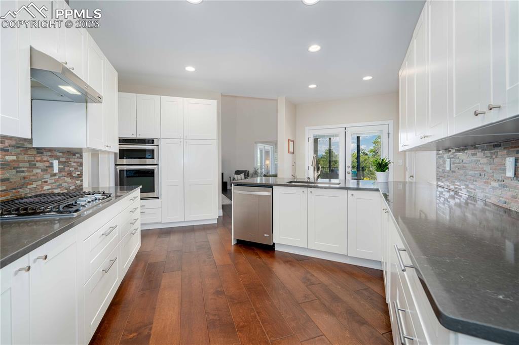 15721 South Furrow Road Larkspur, CO 80118 - Photo 25 of 50 a kitchen with a white stove top oven and white cabinets