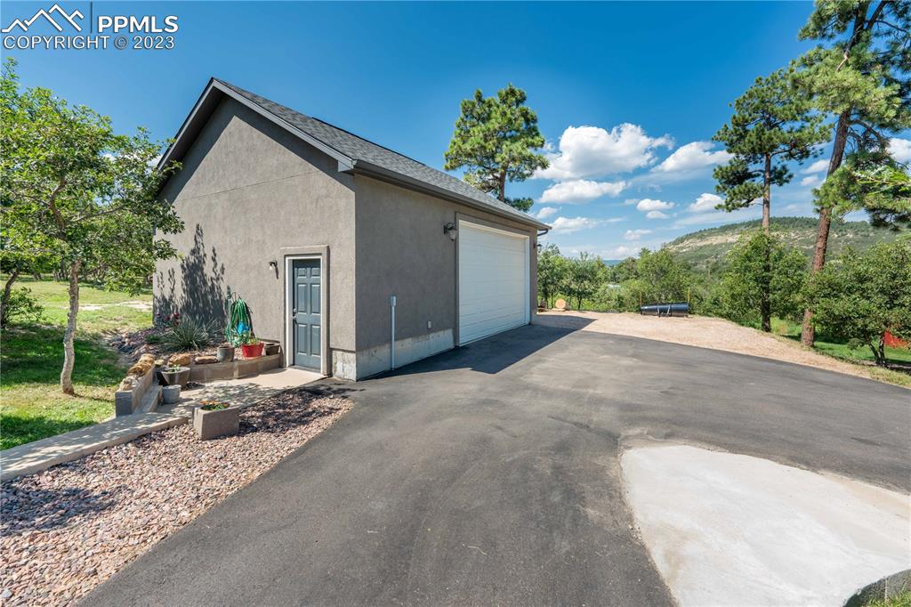 15721 South Furrow Road Larkspur, CO 80118 - Photo 46 of 50 a view of a house with a yard and potted plants