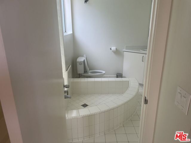 a bathroom with a bathtub sink and mirror