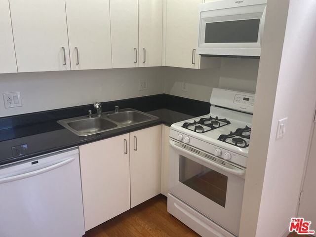 a view of empty room with window and wooden floor