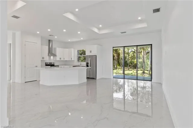 a large white kitchen with a large window