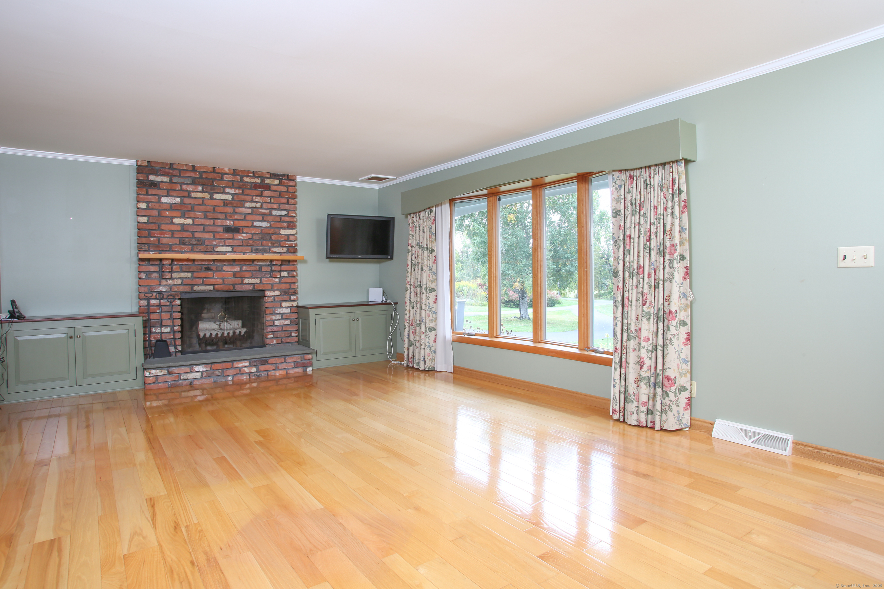 76 Fairchild Road Sharon, CT 06069 - Photo 5 of 39 a view of an empty room with a fireplace and a window