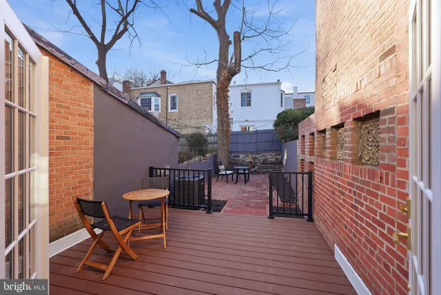 a patio with glass top table and chairs