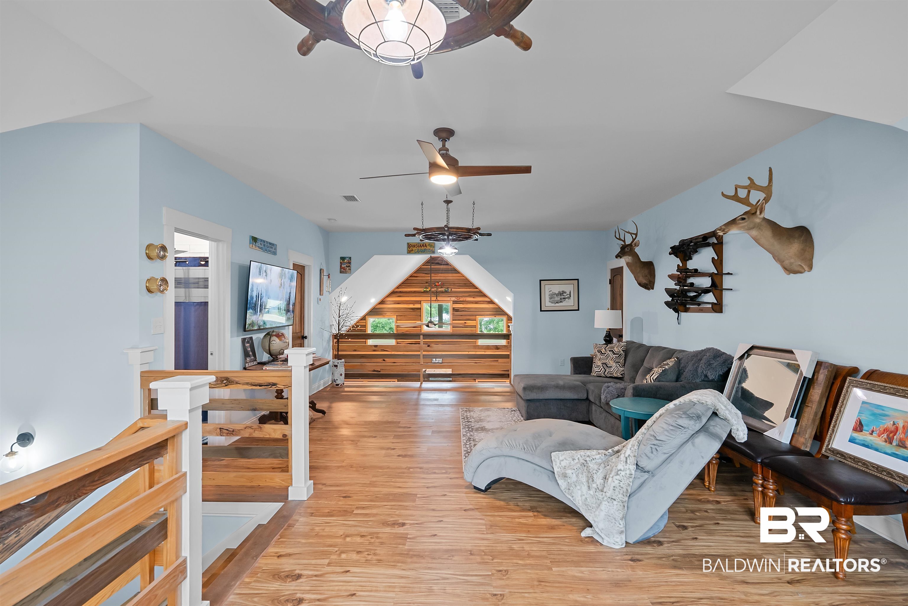 7266 Franklin Road Foley, AL 36535 - Photo 41 of 64 Spacious attic living area featuring wood-finish flooring, a white-painted railing, sloped ceilings, and multiple ceiling fans
