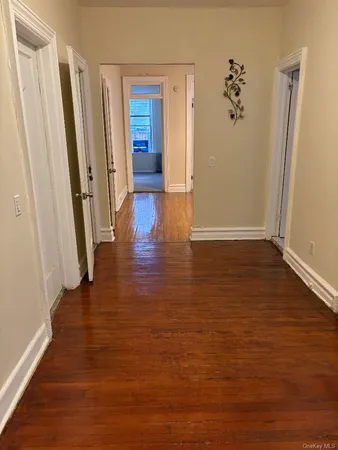 an empty room with wooden floor and closet