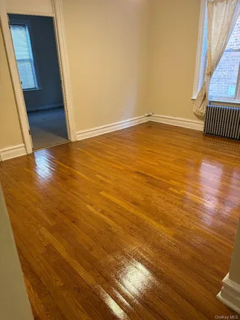 a view of an empty room with wooden floor