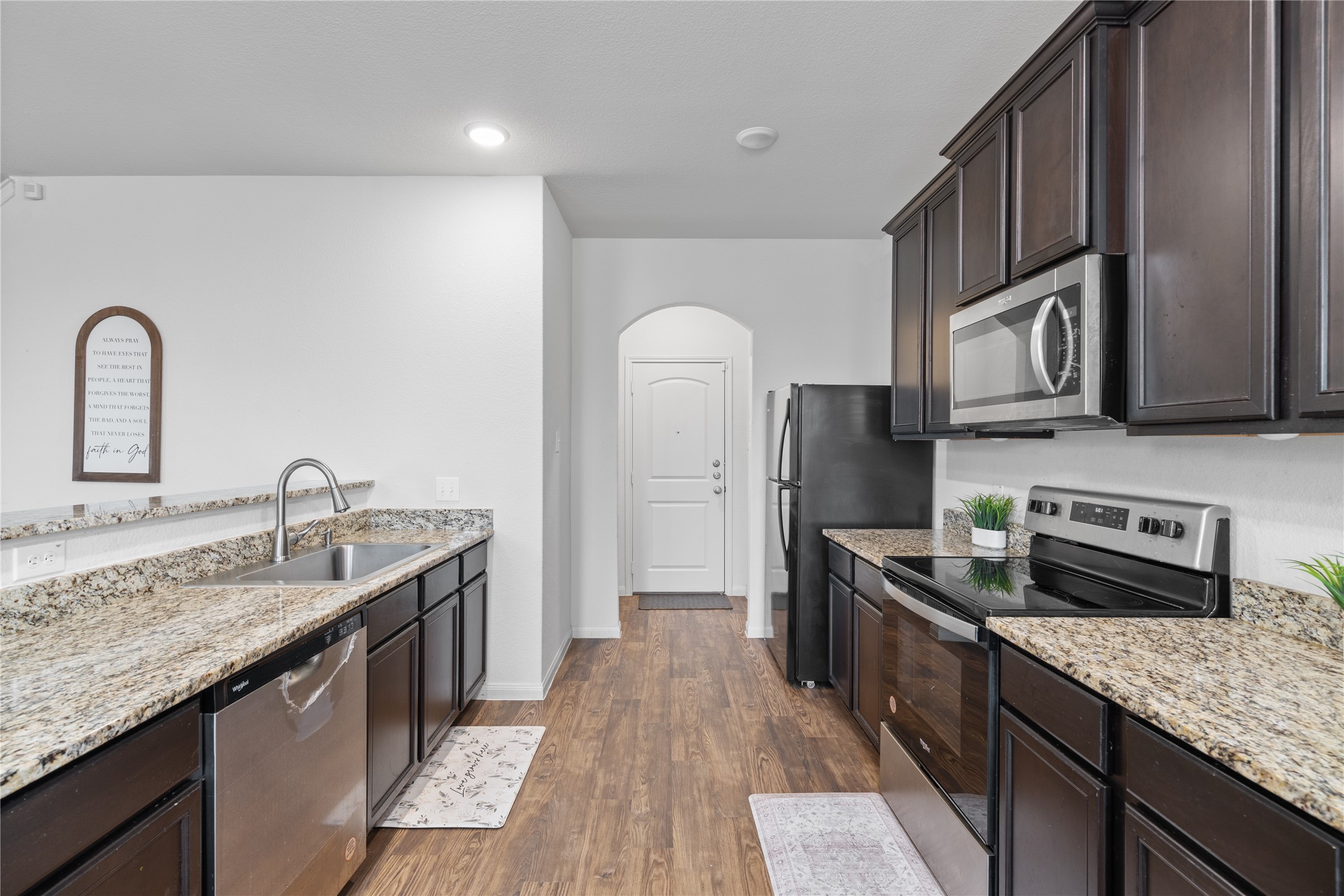 20205 Grover Cleveland Way Manor, TX 78653 - Photo 10 of 26 a kitchen with stainless steel appliances granite countertop a sink stove and refrigerator