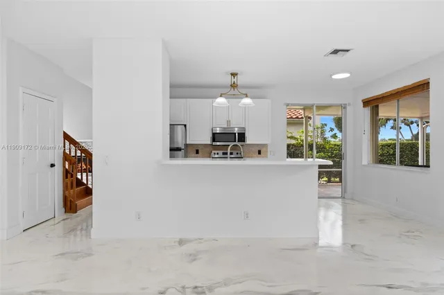 a view of kitchen with cabinets and window