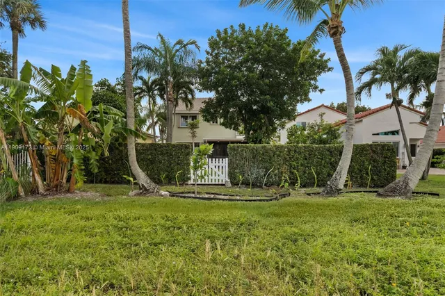an aerial view of residential houses with outdoor space and trees