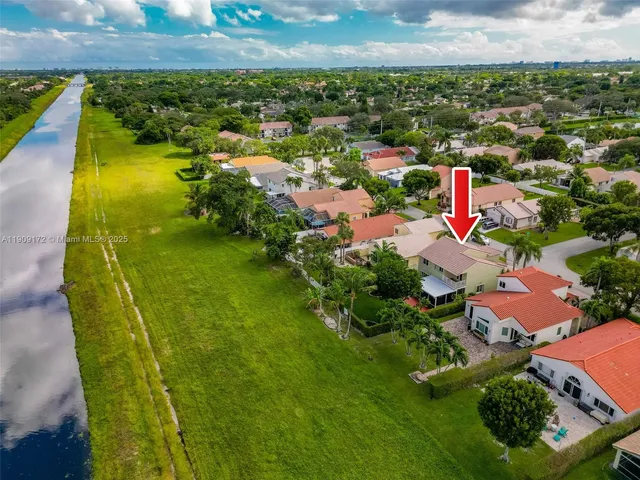 an aerial view of residential houses with outdoor space and swimming pool