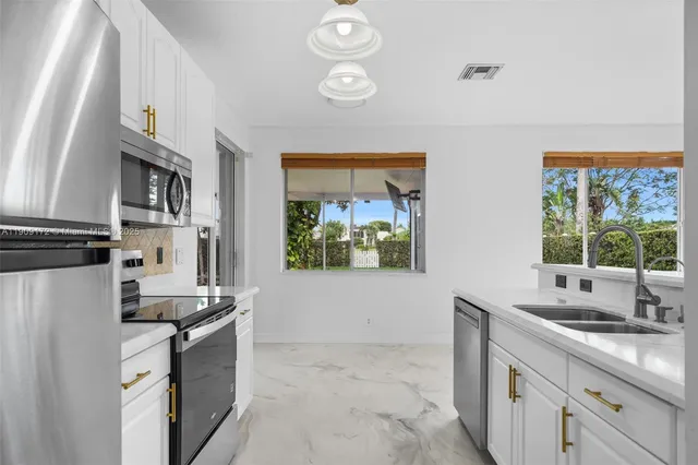 a kitchen with a sink appliances and cabinets