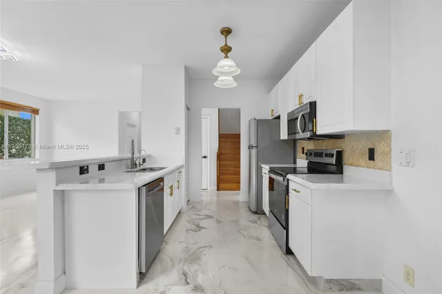 a kitchen with stainless steel appliances and white cabinets