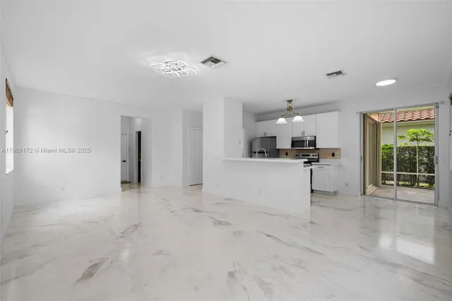 a view of a kitchen with a refrigerator and a stove top oven