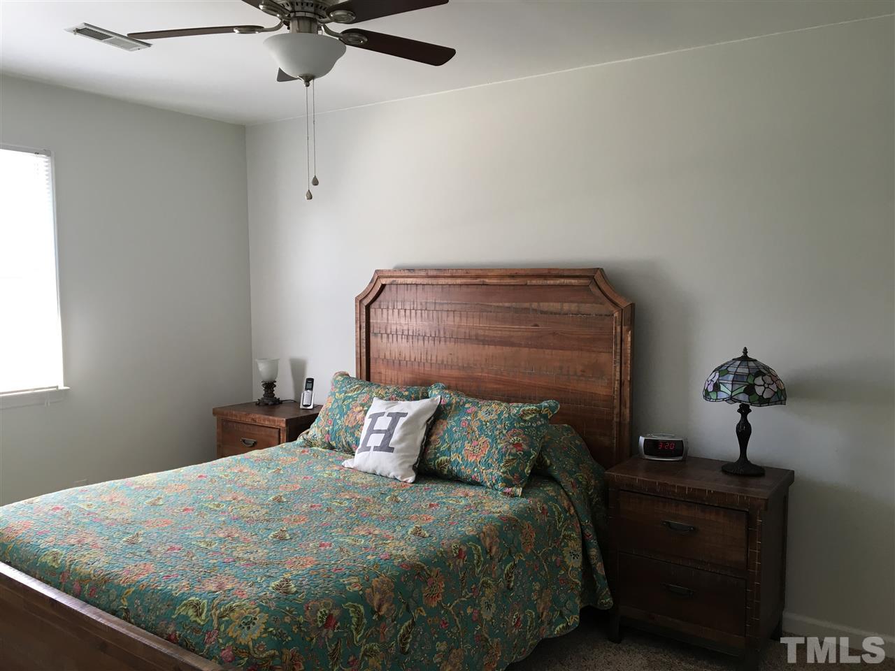 10101 Joe Leach Road Raleigh, NC 27603 - Photo 13 of 15 a bedroom with a bed and wooden floor