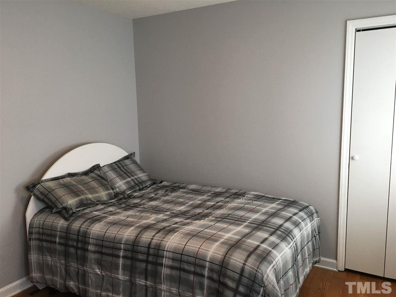 10101 Joe Leach Road Raleigh, NC 27603 - Photo 14 of 15 a bedroom with a bed and a mirror