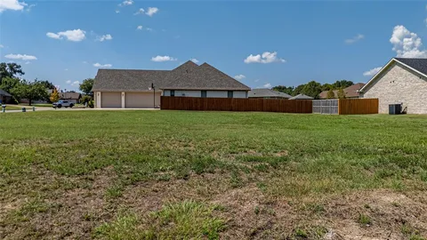 an aerial view of a house with a yard and lake view