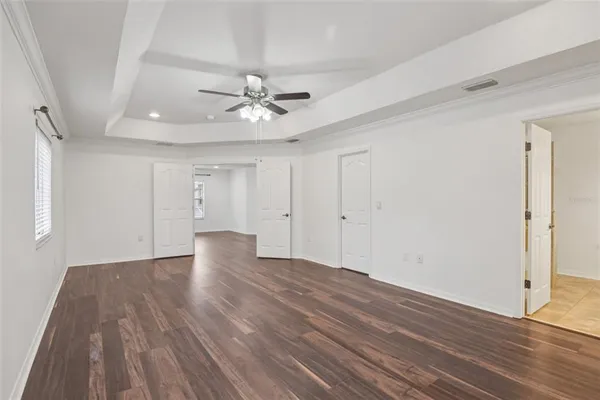a view of an empty room with wooden floor