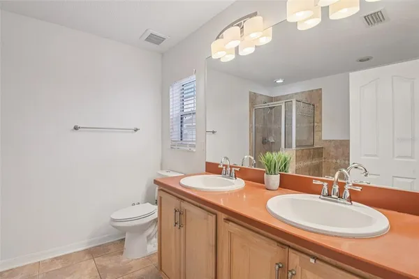 a bathroom with a granite countertop sink a toilet and a mirror