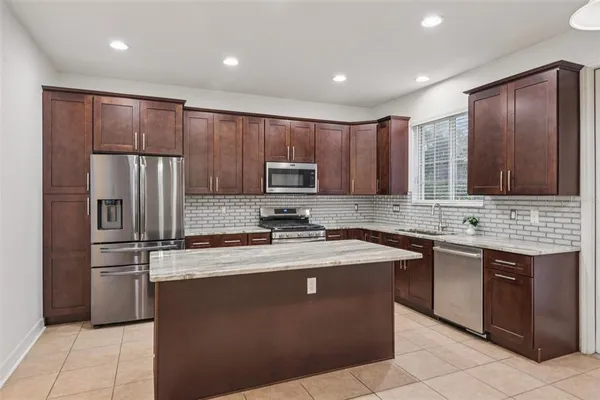 a kitchen with stainless steel appliances granite countertop a refrigerator stove a sink and dishwasher
