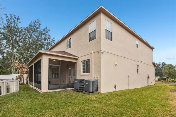 a view of a house with backyard and trees