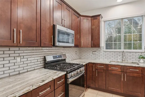 a kitchen with granite countertop cabinets stainless steel appliances and a sink