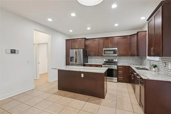 a large kitchen with stainless steel appliances granite countertop a sink and cabinets