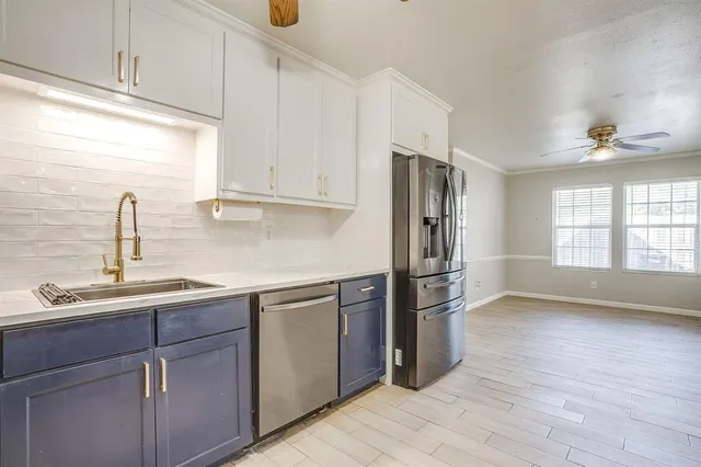 a kitchen with a sink cabinets stainless steel appliances and a window