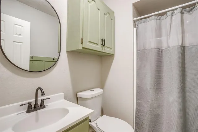 a bathroom with a sink a toilet and a mirror