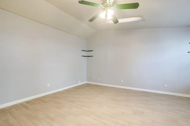 a view of an empty room with a chandelier fan