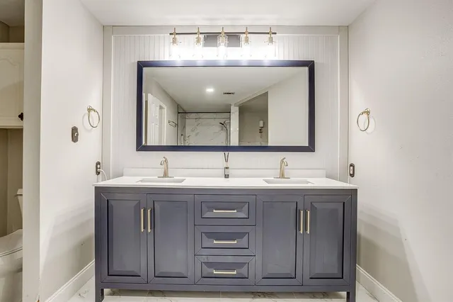a bathroom with a granite countertop sink a large mirror and a