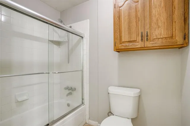 a bathroom with a toilet and a shower