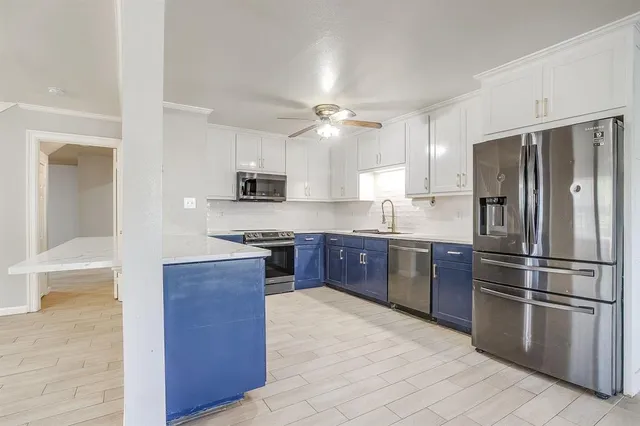 a kitchen with stainless steel appliances granite countertop a refrigerator stove and sink