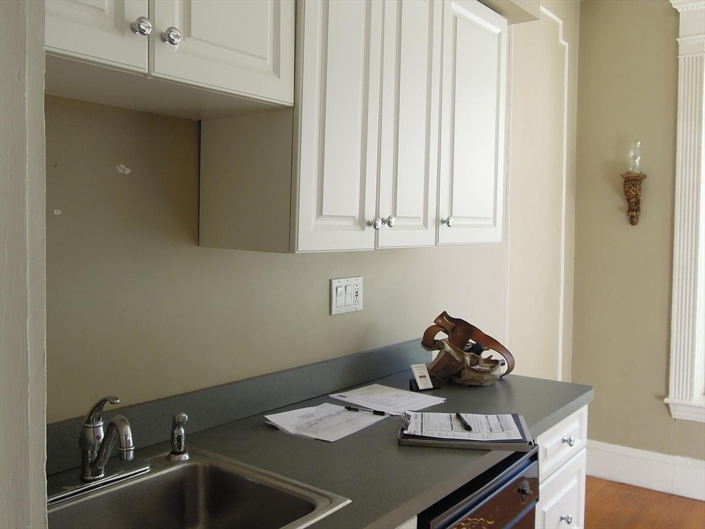 8 Garrison Street, Unit 209 Boston, MA 02116 - Photo 12 of 33 a kitchen with a sink cabinets and a stove top oven