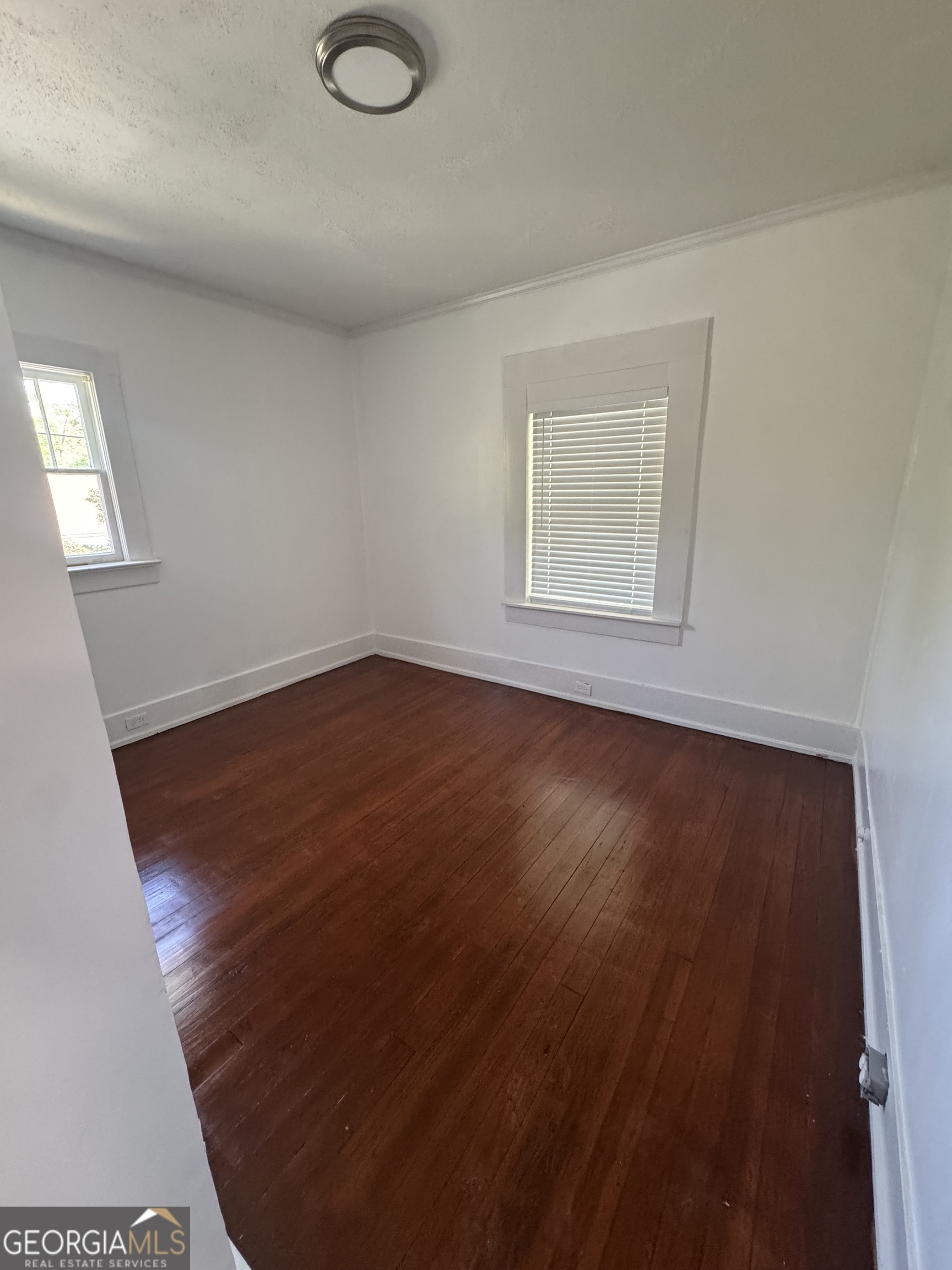 415 Hopkins Street Southwest Atlanta, GA 30310 - Photo 7 of 12 an empty room with wooden floor and windows
