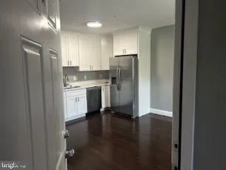 a kitchen with a refrigerator a sink and cabinets