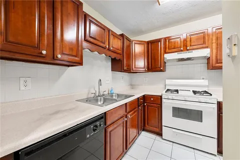 a kitchen with stainless steel appliances granite countertop a sink stove and cabinets