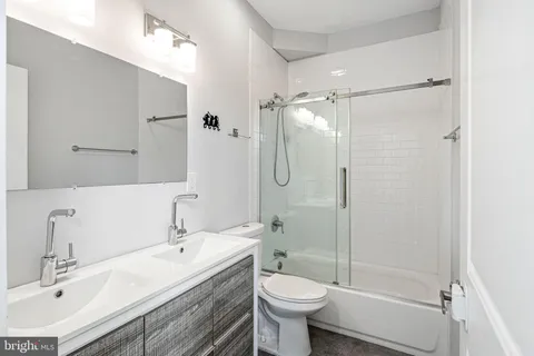 a bathroom with a sink toilet a mirror and shower