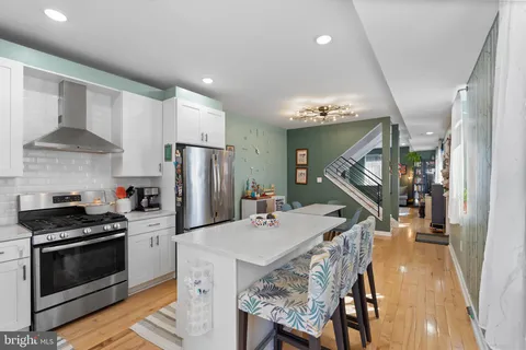 a kitchen that has a table chairs stainless steel appliances and cabinets